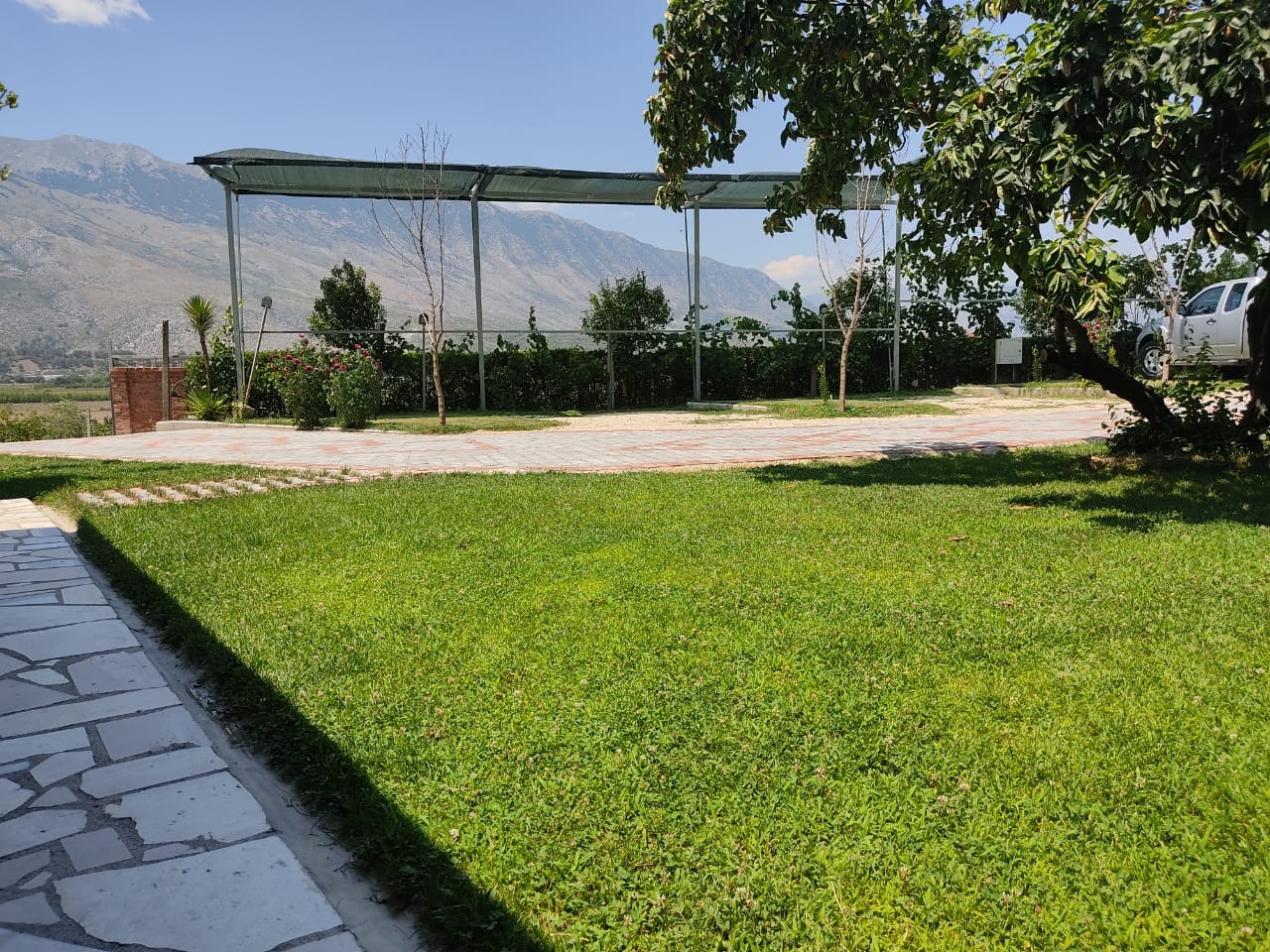 Camping en Albanie avec emplacements ombragés pour camping-cars et montagnes.