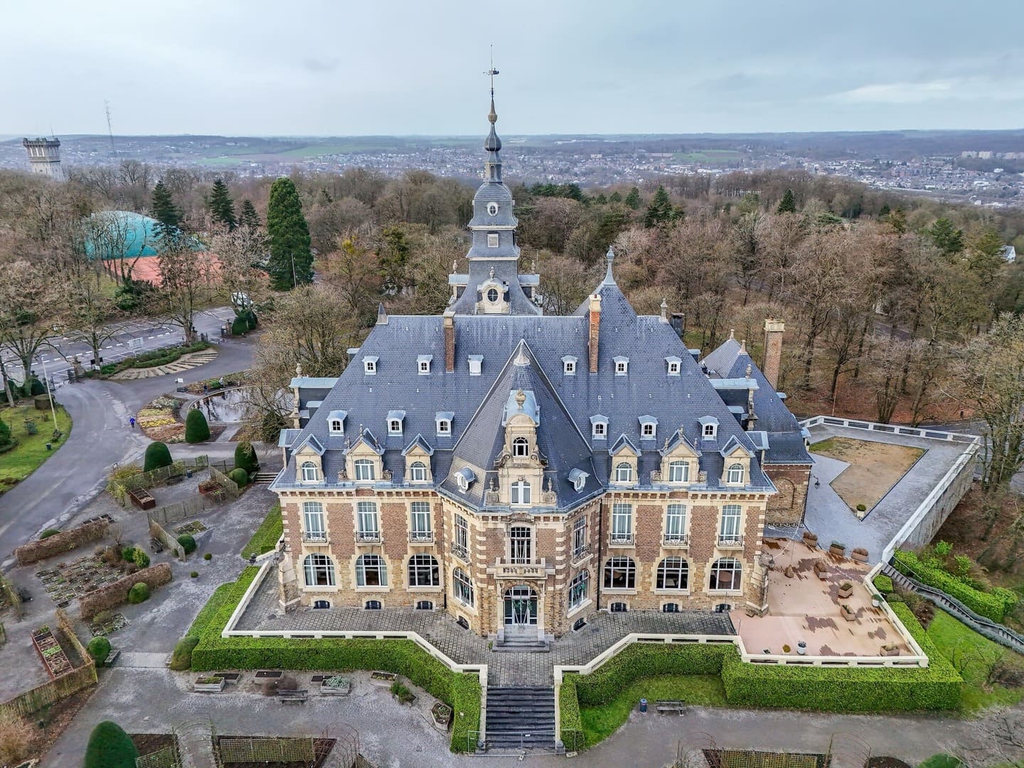 Vue aérienne du Château de Namur entouré de jardins et de forêt.