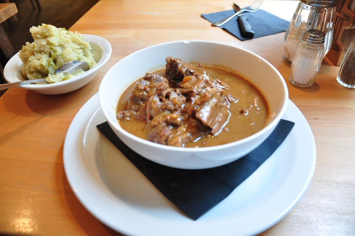 Carbonnade flamande servie avec purée dans un restaurant belge.