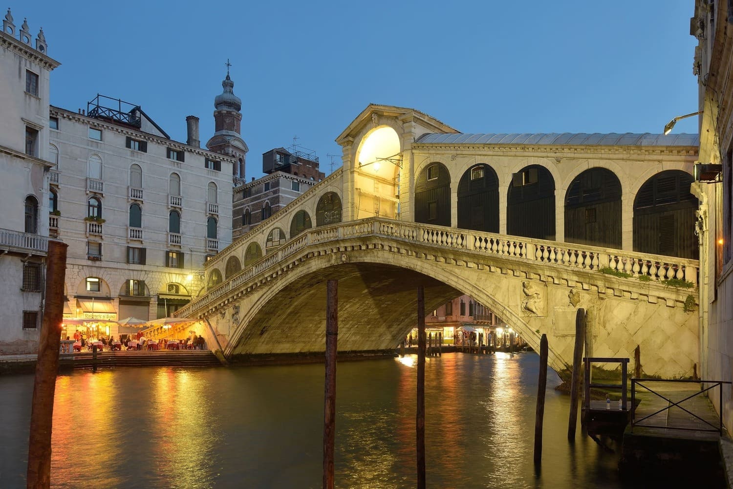 Pont du Rialto illuminé de nuit au-dessus du Grand Canal à Venise.
