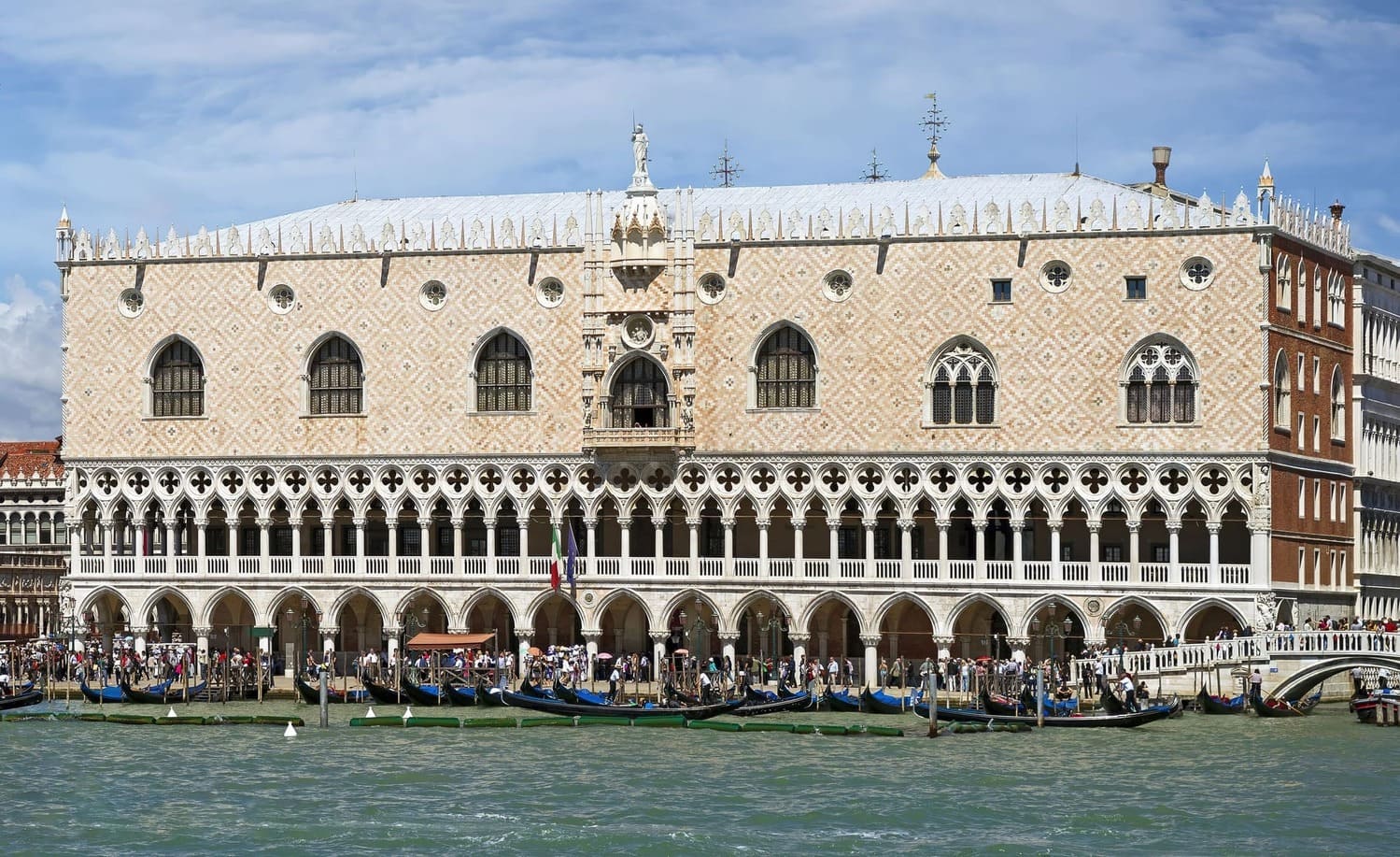 Vue du Palais des Doges le long du Grand Canal à Venise, avec gondoles et architecture vénitienne.