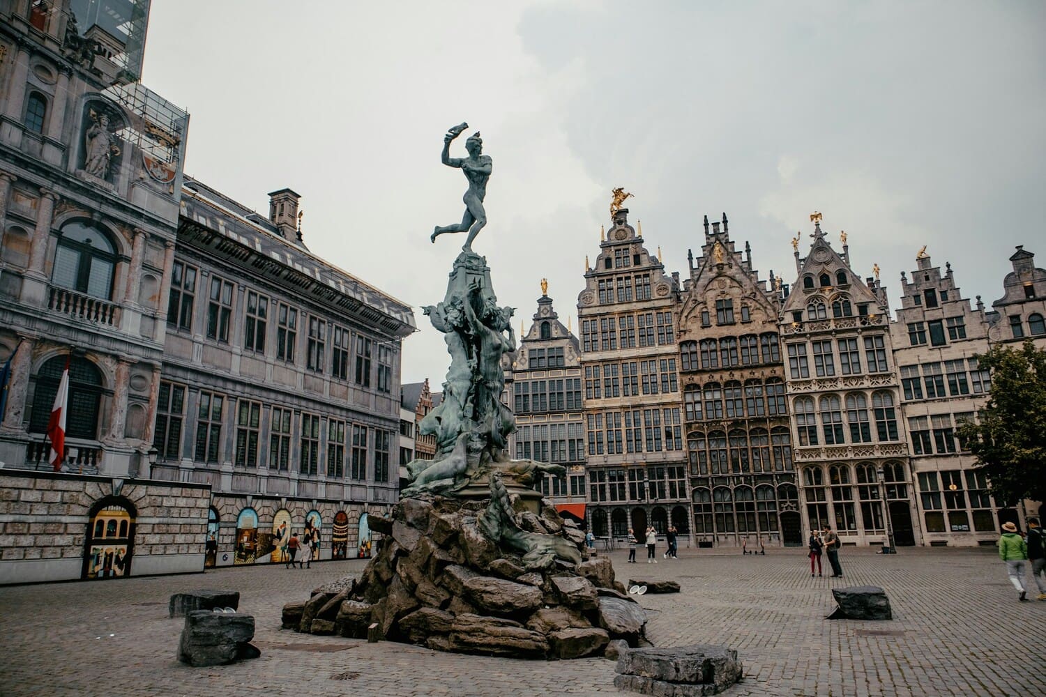 Vue de la fontaine de Brabo sur la Grand-Place d’Anvers, entourée de maisons historiques flamandes.