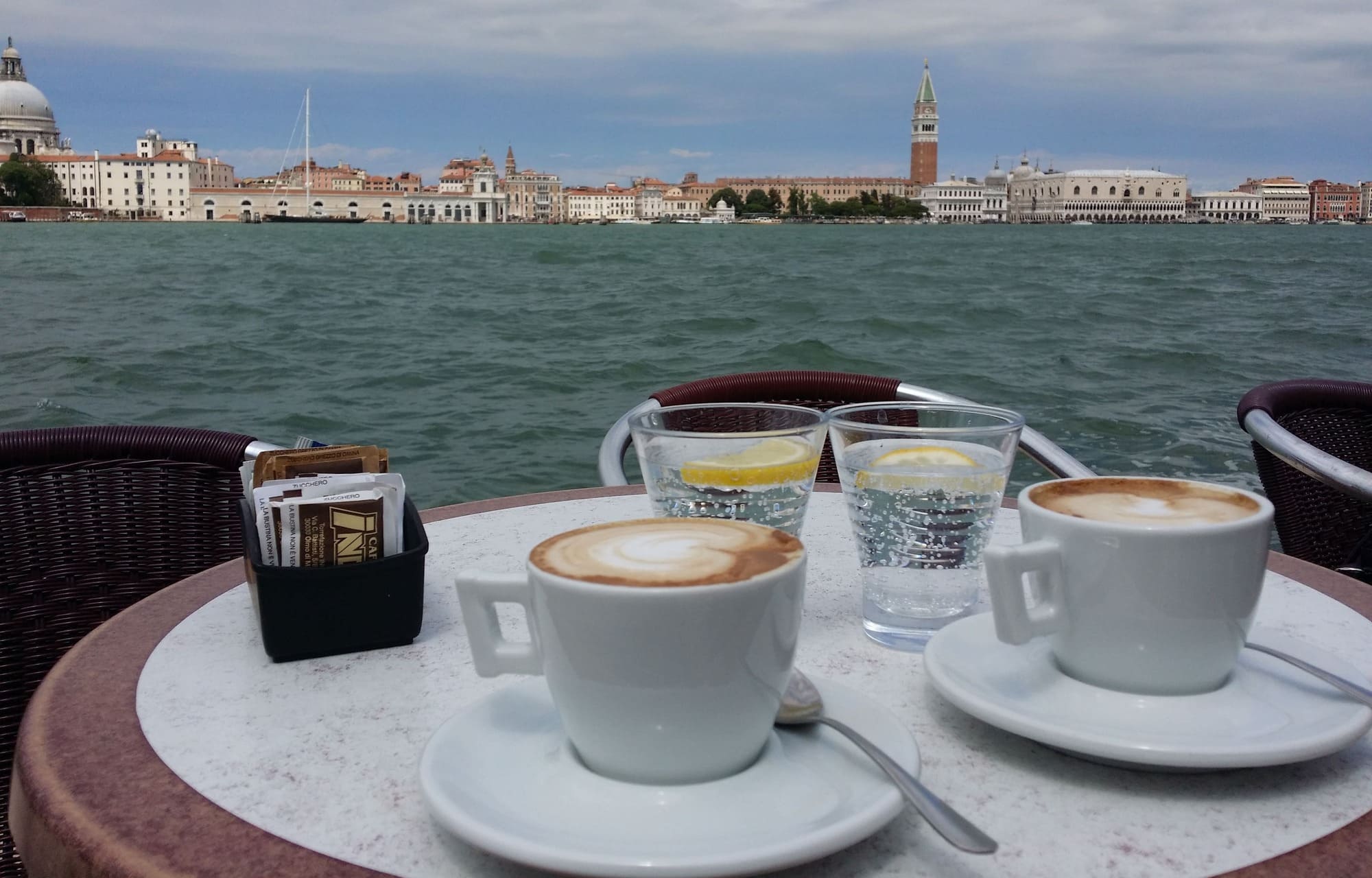Cafés servis en terrasse avec vue sur la lagune et les monuments de Venise.