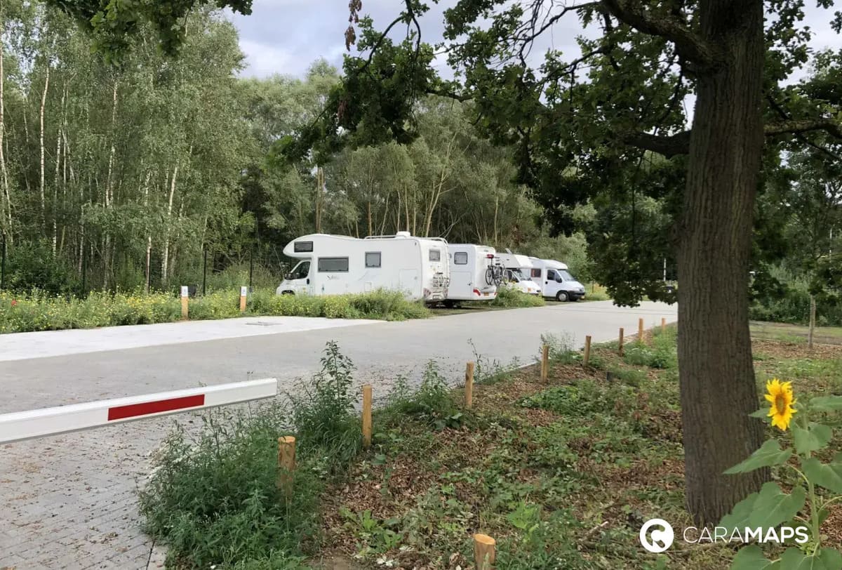 Aire naturelle pour camping-cars à Kessel-Lo entourée d’arbres et d’espaces verts.