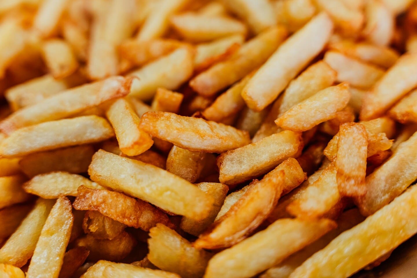 Gros plan sur des frites belges dorées et croustillantes.