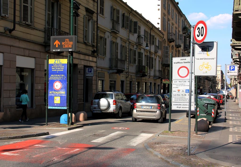 Rue en centre-ville italien avec panneaux de zone à trafic limité (ZTL) et limitation de vitesse à 30 km/h.