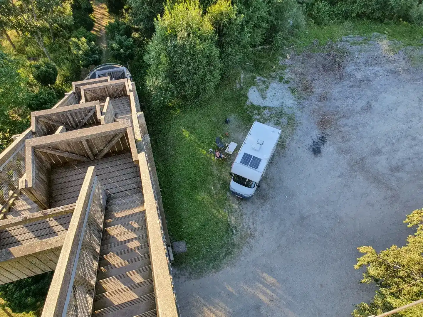 Camping-car stationné près d’une tour panoramique en bois dominant la forêt autour de Bouillon.