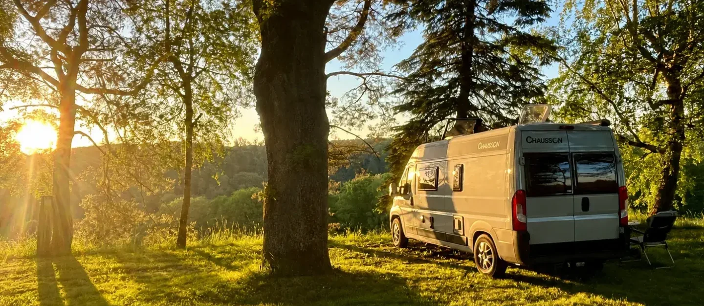 Camper in sosta al tramonto in un'area di servizio, regole sulla sosta notturna 2026