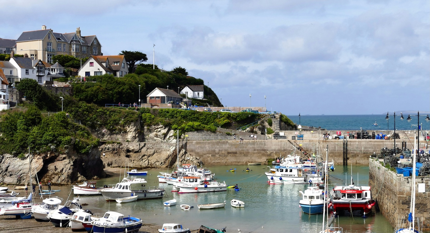 Newquay Harbour, Cornwall, United Kingdom: a picturesque fishing harbour surrounded by colourful coastal buildings, fishing boats and the rugged beauty of the Cornish coastline.