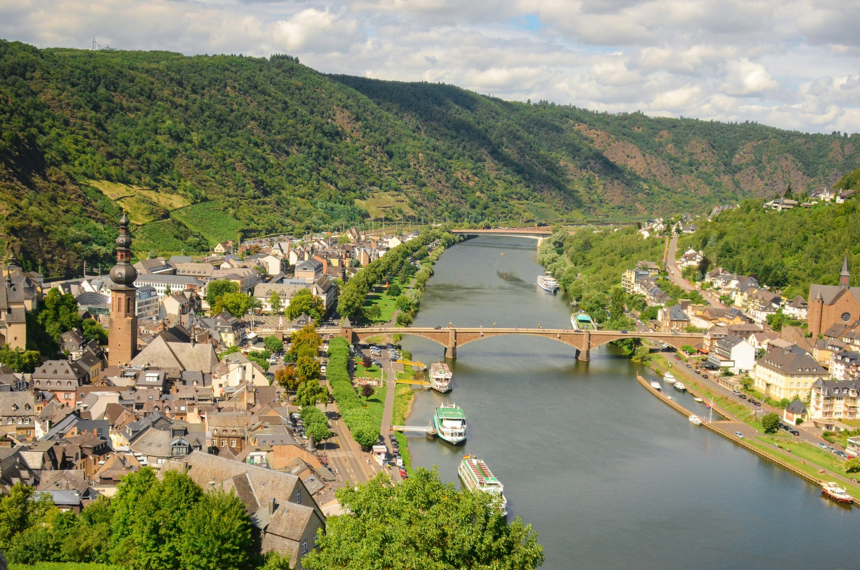 Vue aérienne de Cochem et de la Moselle, avec son pont en pierre, ses bateaux amarrés et ses collines boisées couvertes de vignes, en Allemagne.
