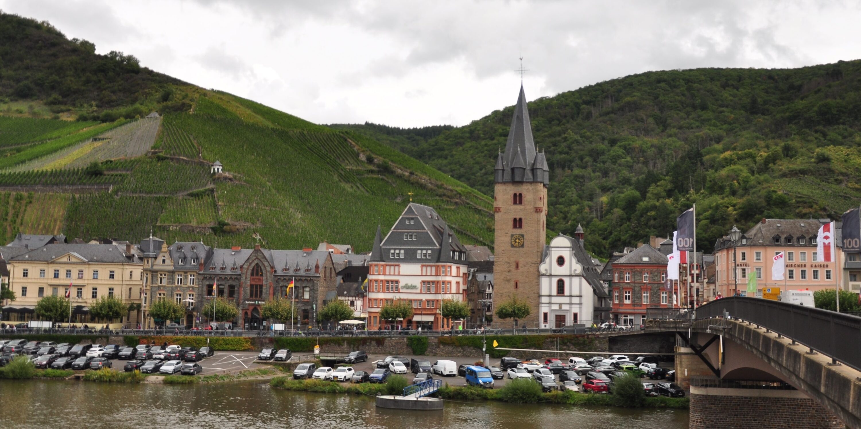 Panoramablick auf Bernkastel-Kues mit seinen historischen Gebäuden, den Weinbergen und der Brücke über die Mosel.
