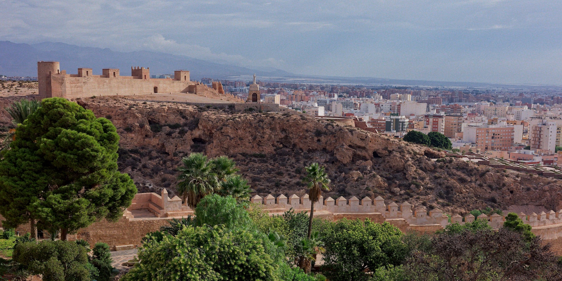 Vista panorámica de Almería, con sus edificios, la Alcazaba y el paisaje mediterráneo al fondo.
