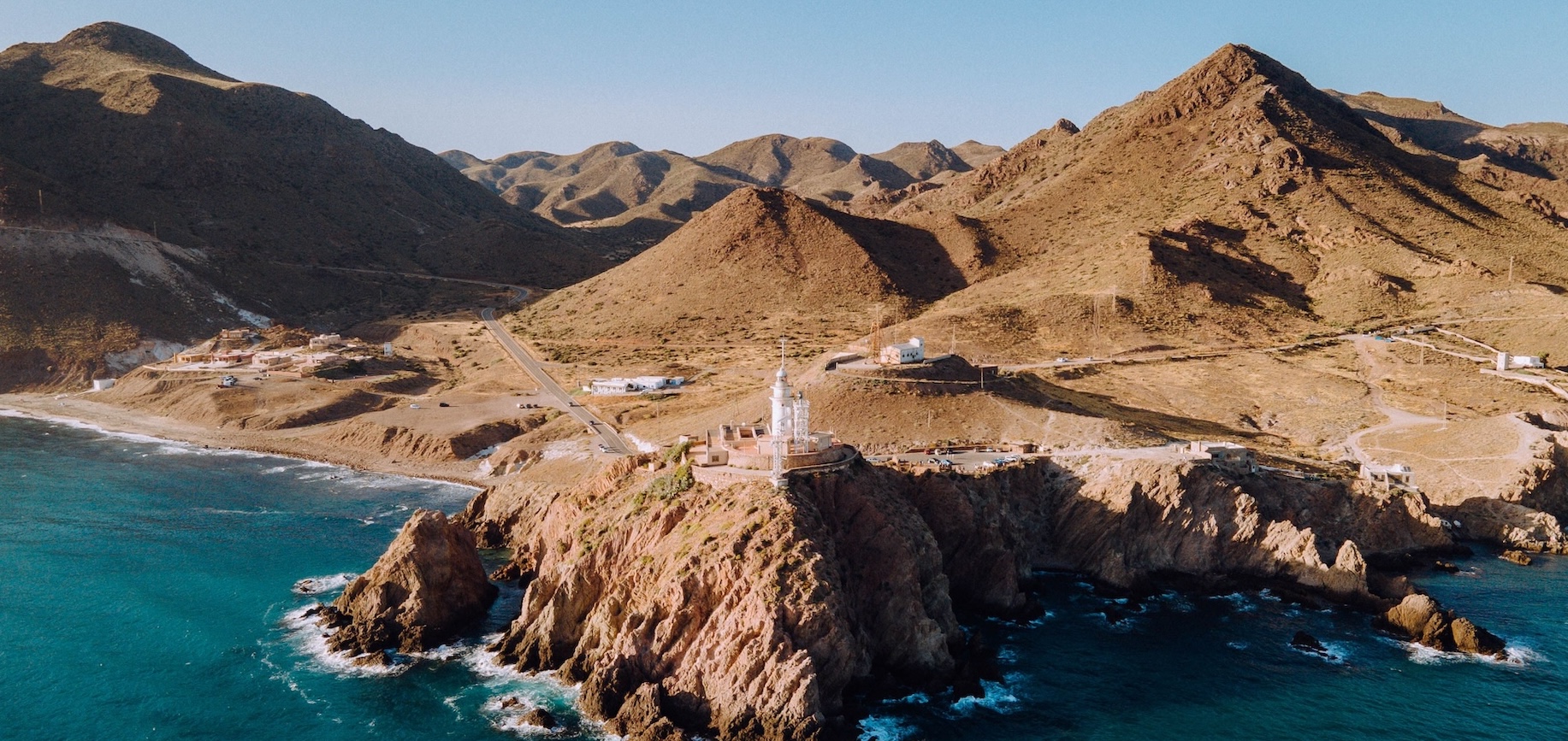 Faro blanco de Cabo de Gata, situado sobre un paisaje rocoso con vistas al mar Mediterráneo.